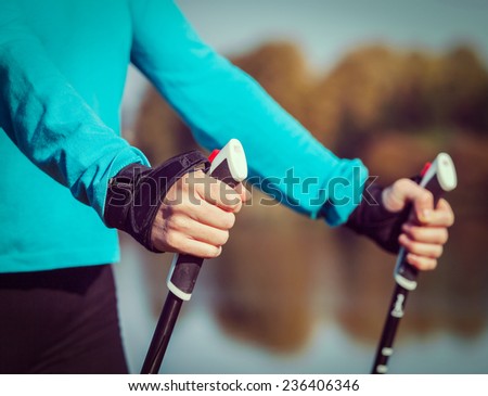 Vintage retro effect filtered hipster style image of nordic walking exercise adventure hiking concept - closeup of woman\'s hand holding nordic walking poles