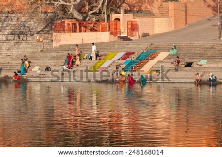 UJJAIN, INDIA - APRIL 25, 2011: People bathing and washing clothes in the morning on ghats of holy Kshipra river. Shipra is one of the sacred rivers in Hinduism