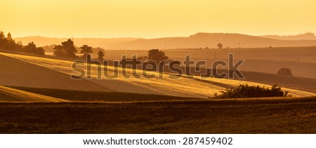 Panorama of Moravian rolling landscape on sunset in yellow colors. Moravia, Czech Republic