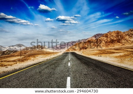Travel forward concept background wallpaper - road in Himalayas and blue sky dramatic clouds. Ladakh, Jammu and Kashmir, India