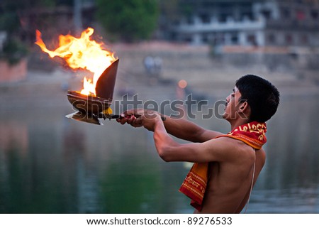 UJJAIN, INDIA - APRIL 23: Brahmin performing Aarti pooja ceremony on bank of river Kshipra on April 23, 2011 in Ujjain, Madhya Pradesh, India