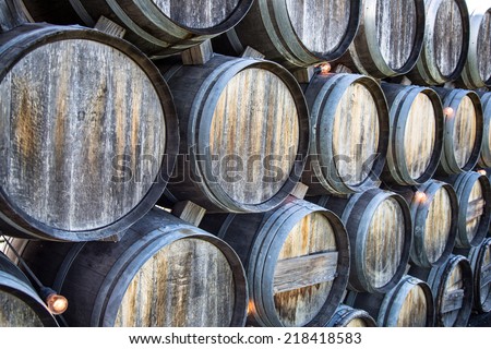 Rustic oak wine barrels stacked at a California winery.