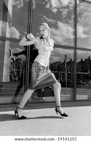 Beautiful girl, blond, runs against the backdrop of the station. In all growth.