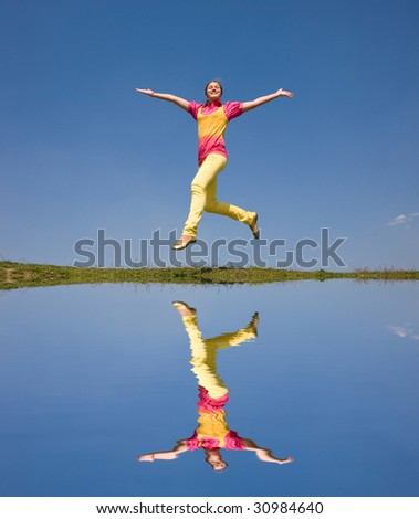 Happy smiling girl - jumping. Reflected in water
