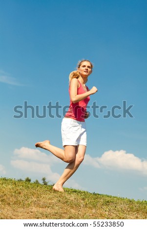 Happy young woman running in field
