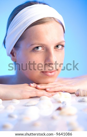 young beautiful smiling woman relaxing with sea shells in the spa