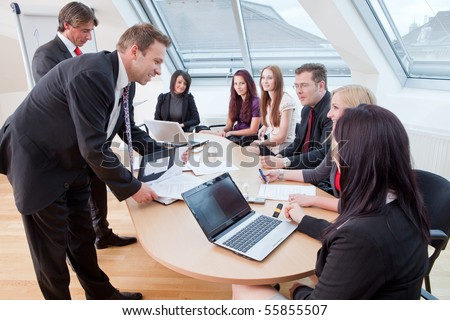 seven people having a meeting in the conference room