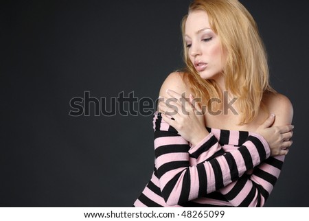 Beautiful blonde woman in black and pink top with hands on shoulders