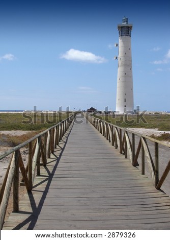 Lighthouse with footbridge at the beach of jandia fuerteventura, spain