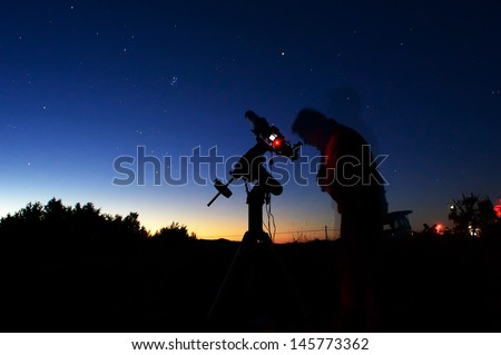 Astronomer in the night with telescope