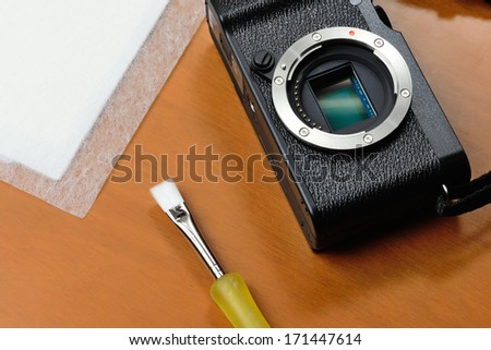 Cleaning a sensor camera lens with rice paper and a brush