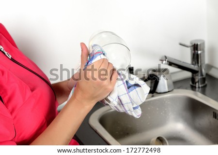 girl washes dishes by hand in the sink