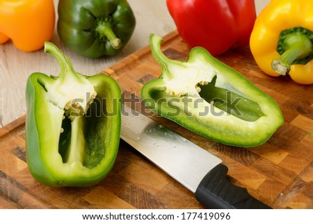 Red, yellow, green bell pepper with knife
