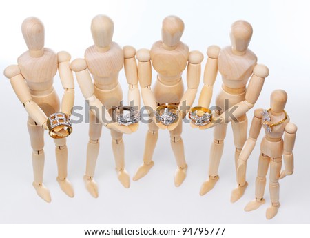 Five Wooden puppets holding golden ring with diamond, isolated on white background.