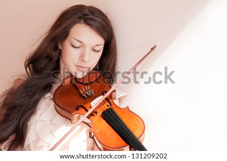 Pretty young female playing the violin, soft focus.