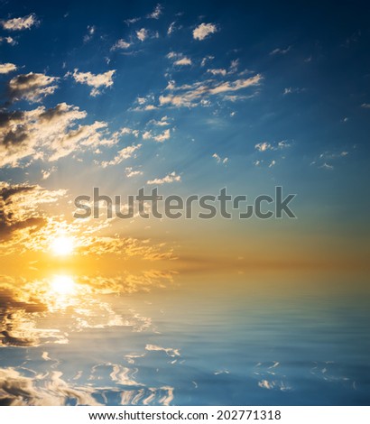 Sunset with clouds reflected in water.