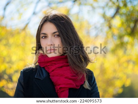 Beautiful young woman in a black jacket with red scarf. Autumn portrait.