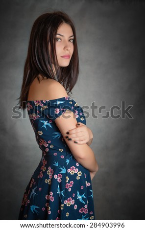 Happy beautiful woman in sundress on grey background.