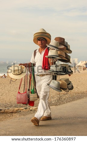 PUERTO VALLARTA, MEXICO - FEBRUARY 7:  Mexican Street vendor sells hats and purses on February 7, 2014 on the waterfront, Malecon, in Puerto Vallarta, Mexico