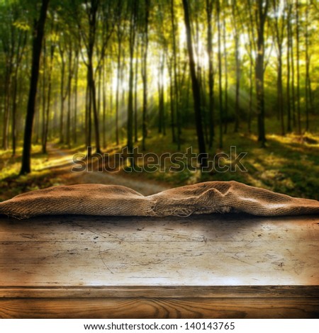 Empty wooden table in dark autumn forest. Great background for product display.