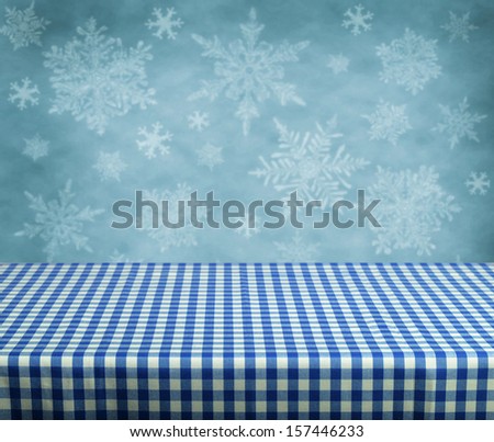Empty table with blue gingham tablecloth over winter background. Great for product display montages