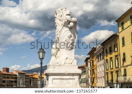 Pisa (Tuscany, Italy) - White statue of a lion and colorful houses along the Arno river
