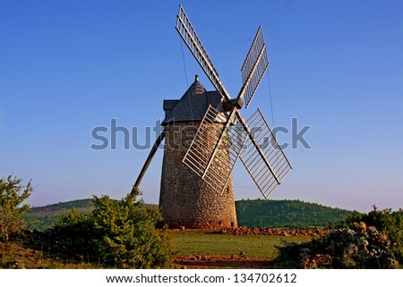 An old mill in the sunset with a blue sky