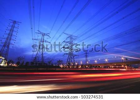 long exposure of night car rainbow light traffic on a highway and transmission tower at night skyline