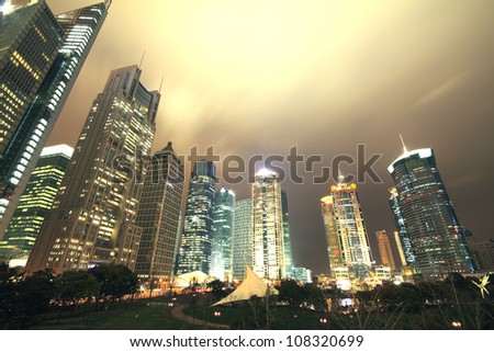 Looking up at the modern office buildings at night in Shanghai