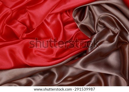 Brown and red Silk cloth of abstract backgrounds or wavy folds or satiny silk texture satin velvet material or elegant wallpaper design curve