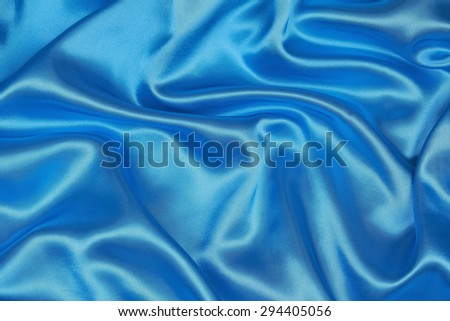 Blue Silk cloth of abstract background or wavy folds or satiny silk texture satin velvet material or elegant wallpaper design curve.