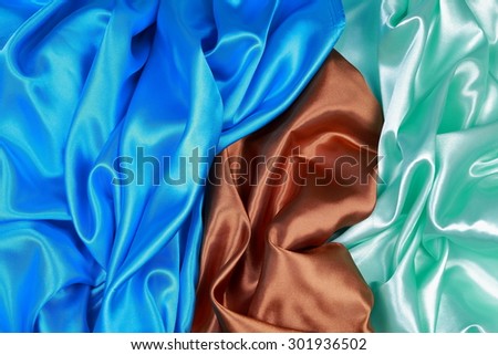 Blue and brown and light green silk texture satin velvet material or elegant wallpaper design curve folds wavy background