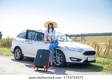 Pretty girl with suitcase standing near car and wiat for her dreaming trip Zdjęcia stock © 