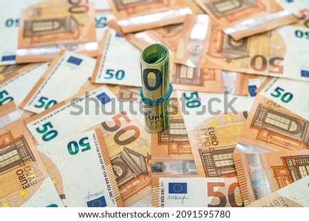 new orange 50 euro banknotes are scattered on the table on which 100 euro are twisted into a tube and pulled with a rubber band. Money concept 商業照片 © 