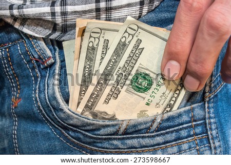 hand holding dollar cash taking out of jeans pocket