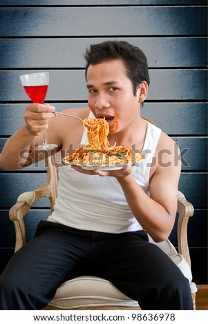 man eating spaghetti with  behind old wall