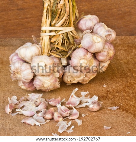garlic on brown textured wood.It is a herb.