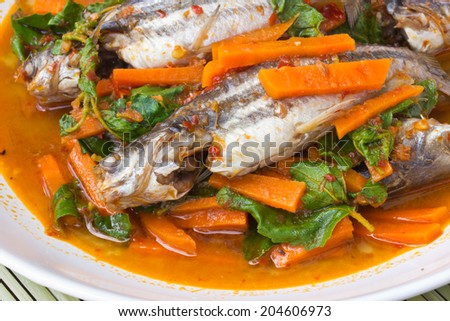 Fish Curry in white dish on bamboo brown straw