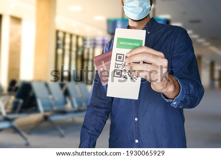 unidentified manwearing a face mask and holding a passport and a Green pass certificate of vaccination.The European Union will propose issuing a certificate called a Digital Green Pass Photo stock © 