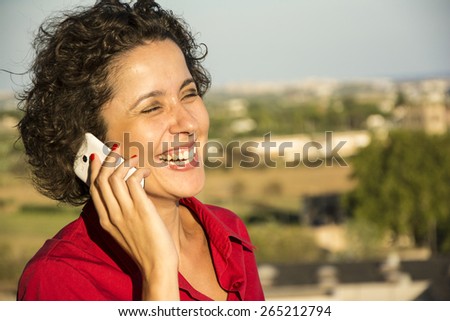 Beautiful woman laughing and  talking on the cell phone. Woman and technology