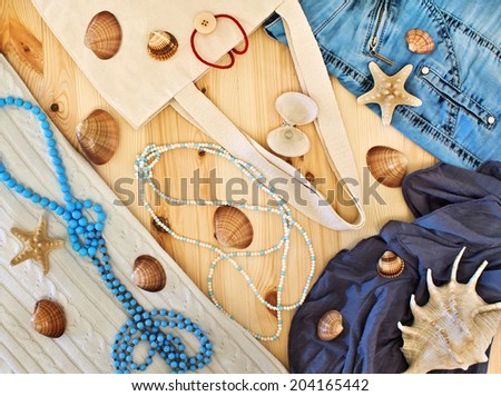 Women\'s clothing, beads and seashells on a wooden background.