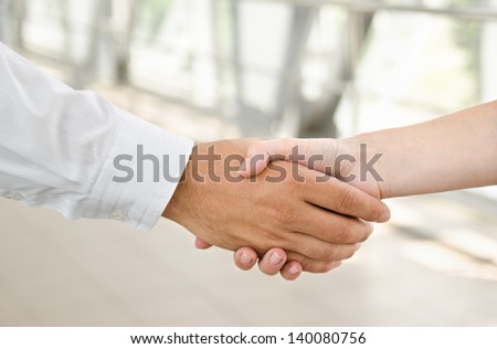Man and woman  handshake isolated on business background