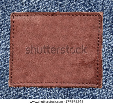 blank reddish leather label on jeans background Can be used for Your text