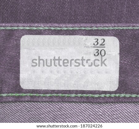 fabric label on violet jeans background,