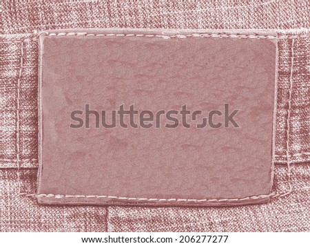 blank red leather label on red jeans background