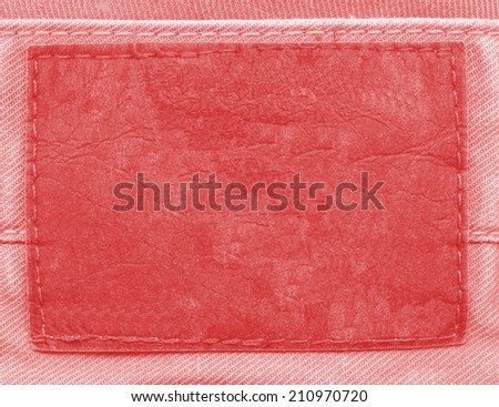 blank old red leather label on fabric background