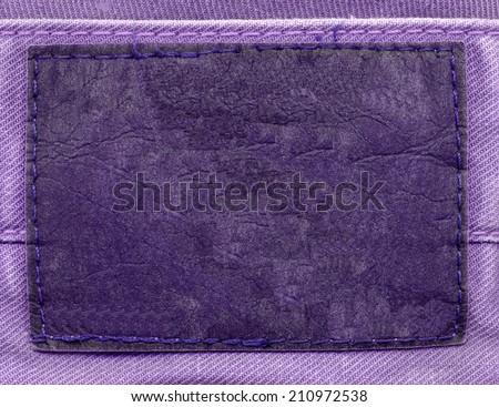 blank old  violet leather label on fabric background