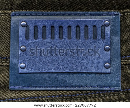blue leather label on greenish jeans background