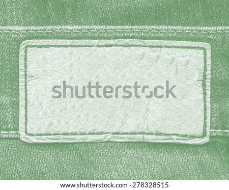pale green leather label on green jeans background