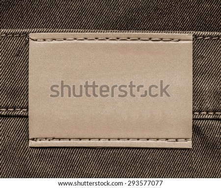 light brown  leather jeans label on background of brown denim